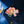 Pink floral brooch with pearl center on a dark blue velvet background