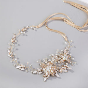 Delicate gold and pearl headband on a light gray background