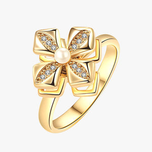 Gold ring with bow design and small diamonds on a white background