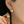 Gold earrings with pearl accents worn by a person