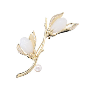 Gold brooch with white stones on a white background
