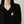 Floral brooch on a black blazer against a neutral background