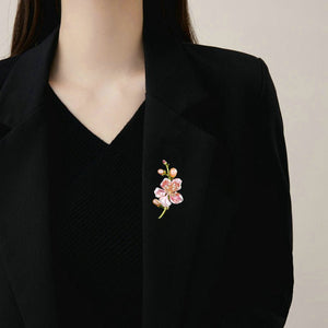 Floral brooch on a black blazer against a neutral background