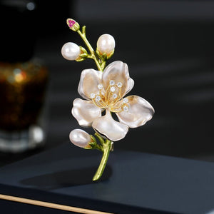 Decorative flower brooch with pearls and gemstones on a dark background