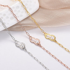 Three pearl-linked necklaces in silver, rose gold, and gold on a white background.
