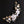Decorative floral hairpiece with white flowers and gold leaves on a black background