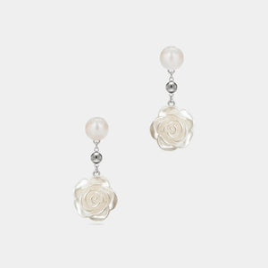 Pair of earrings with floral designs and pearl-like beads on a white background