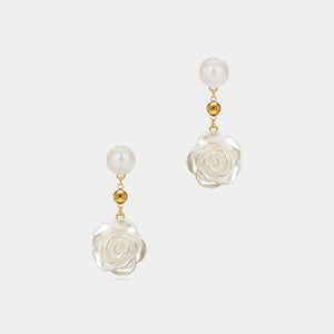Pair of earrings with floral design and pearl-like beads on a white background