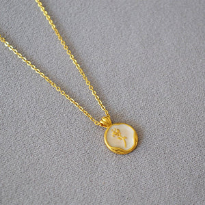 A collection of three pearl necklace chains with gold-plated rose flower pendants, displayed on a grey background.