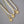 Two pearl necklaces with gold pendants on a gray surface