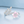 Silver ring with pink flower design on a light blue background