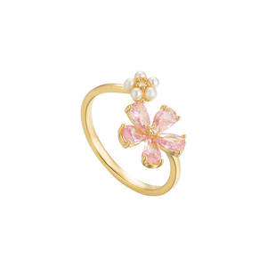 Gold ring with pink gemstone and pearl on a white background