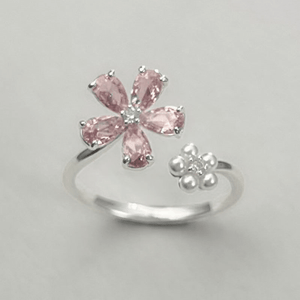 Silver ring with pink gemstones on a gray background