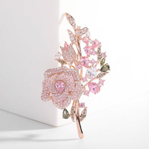 Ornate brooch with pink gemstones on a white background