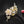 Gold and diamond flower brooch on a black background