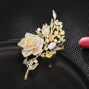 Gold and diamond flower brooch on a black background
