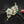 Gold brooch with green gemstones on a black background
