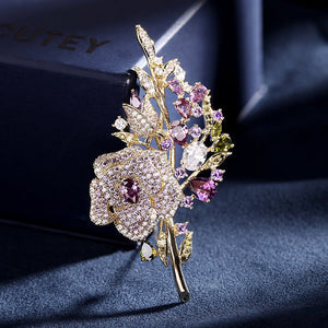 Decorative brooch with floral design and gemstones on a dark fabric background