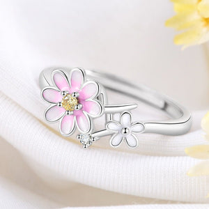Silver ring with pink and white floral designs on a light background