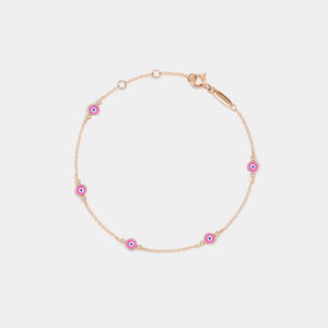 A gold-plated sterling silver bracelet featuring multiple small pink enamel charms designed to resemble evil eyes, set on a white background.