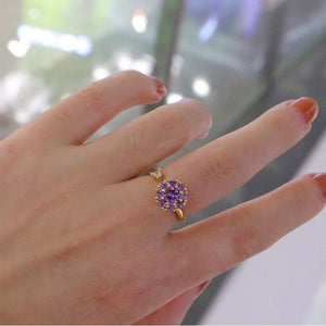 Two rings, one with a clear and one with pink cubic zirconia stones, both with a floral design, displayed against a white background.
