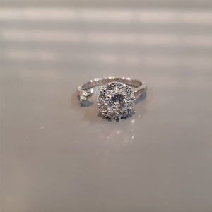 Two rings, one with a clear and one with pink cubic zirconia stones, both with a floral design, displayed against a white background.