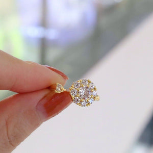 Two rings, one with a clear and one with pink cubic zirconia stones, both with a floral design, displayed against a white background.