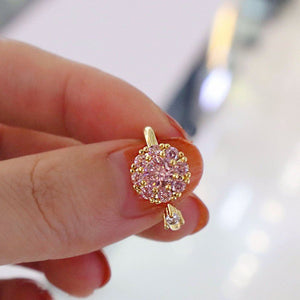 Two rings, one with a clear and one with pink cubic zirconia stones, both with a floral design, displayed against a white background.