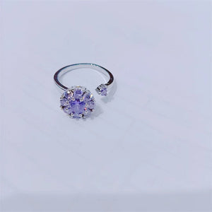 Two rings, one with a clear and one with pink cubic zirconia stones, both with a floral design, displayed against a white background.