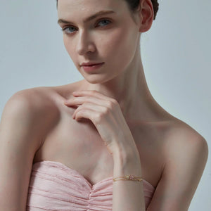 Woman wearing a strapless pink dress with a plain background