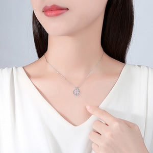 Necklace with a pendant worn by a person, pointing to it.