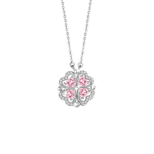 Silver necklace with a clover-shaped pendant featuring pink gemstones on a white background