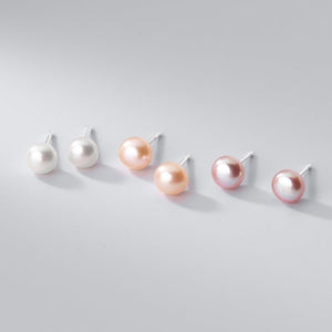 Set of pearl earrings in various colors on a light gray background