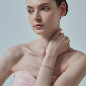 Woman wearing a pink strapless top against a light background