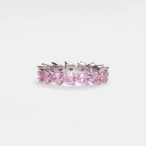 Silver ring with pink gemstones on a white background