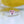 Heart-shaped pink gemstone ring with diamond accents on a white and yellow background