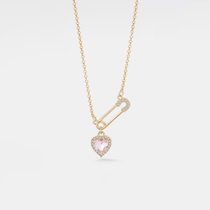 Gold necklace with a pink heart-shaped pendant on a light gray background