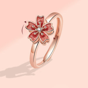 Rose gold ring with a red floral design on a pink background
