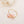 Gold ring with two pink pearls on a light background