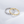 Two rings, one gold and one silver, with embedded stones on a light gray background