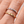 Two gold and silver rings with embedded gemstones on a finger.