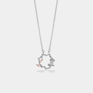 Silver necklace with a delicate pendant on a light gray background