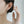 Close-up of a person wearing a silver paw print earring with a blurred background