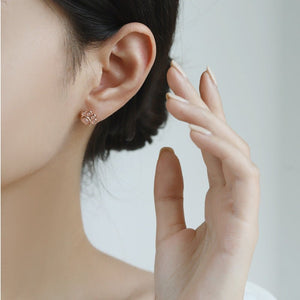 Close-up of a person wearing a paw print earring with a blurred background