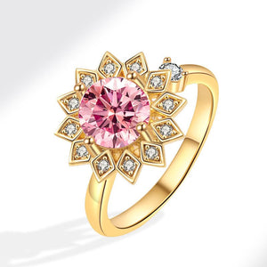 Gold ring with a pink gemstone and diamond accents on a white background