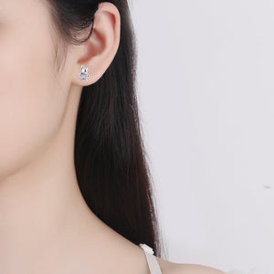Earring worn by a model on a plain background