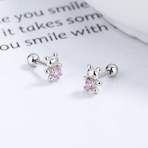 Silver earrings with pink gemstones on a white surface