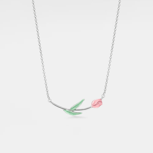 A silver necklace with a charm depicting a horizontal tulip flower, featuring green leaves and a pink petal.