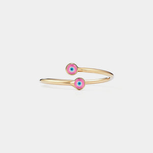 Gold ring with pink evil eye charms on a light gray background