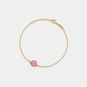 Gold bracelet with a pink evil eye charm on a white background